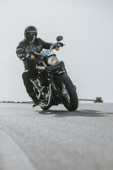 Obraz premium Zamknij się motocykl skręcając na asfalcie drogi.