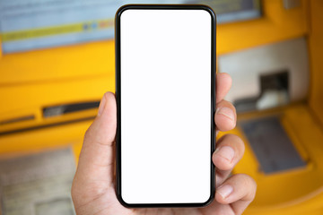 man hand holding phone with isolated screen on yellow ATM