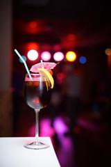Cold cocktail on a dark background with a bright bokeh.
