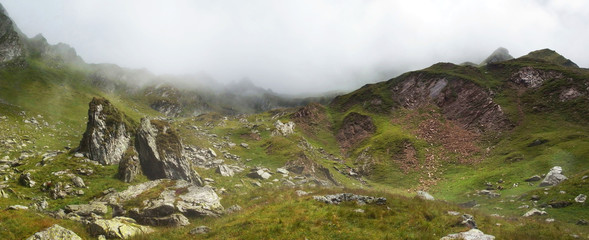 Rumunia, Karpaty Rumuńskie - Góry Fagaras, podejście z Doliny Doamnele (Dolina Księżniczki) na przełęcz Curmatura Doamnei, skały w chmurach i słońcu © Iwona