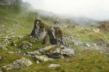 Rumunia, Karpaty Rumuńskie - Góry Fagaras, podejście z Doliny Doamnele (Dolina Księżniczki) na przełęcz Curmatura Doamnei, skały w chmurach i słońcu © Iwona