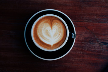 Cloase up coffee cup on wooden table in coffee shop.