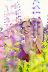 A woman looks out from behind the flowers