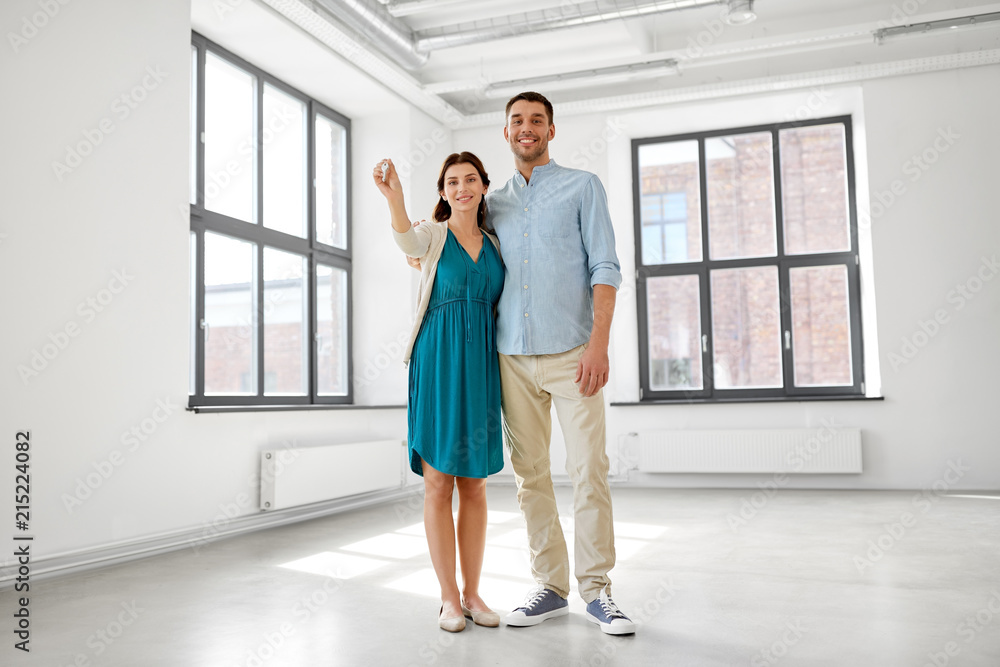 Poster mortgage, people and real estate concept - happy couple with keys at empty room of new home