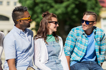 people, friendship and international concept - group of happy smiling friends in sunglasses in city