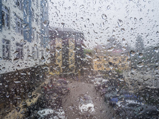 Glass in droplets from the rain in the background of the street yard