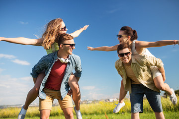 leisure, people and friendship concept - happy teenage friends having fun outdoors in summer