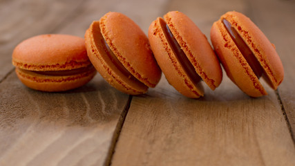 Orange macarons on a wooden table, with a vintage style.