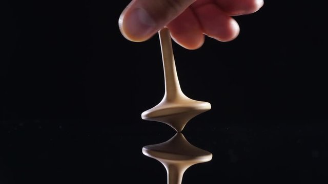 Close up shot of a wooden spinning top moving.
