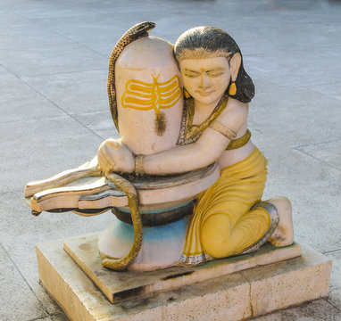 Statue with worshiper making puja to yoni lingam