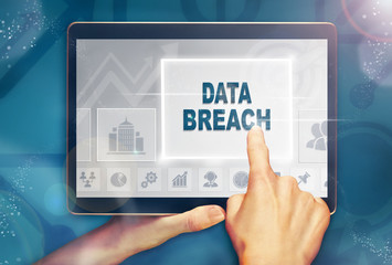 A hand selecting a data breach business concept on a computer tablet screen with a colorful background.