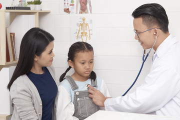 Doctor talking to young child and mother