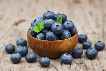 Blueberries in a wood bowl on a wooden table, Healthy eating and nutrition concept