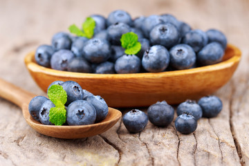 Blueberries in a wood bowl on a wooden table, Healthy eating and nutrition concept