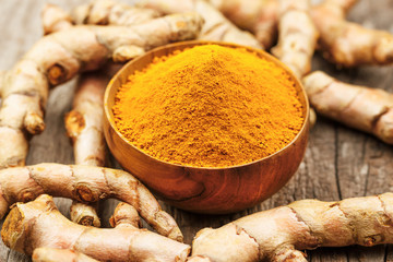 Turmeric powder in wooden bowls on wooden table