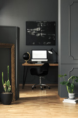Dark living room interior with molding on walls in real photo with green plants, modern painting...