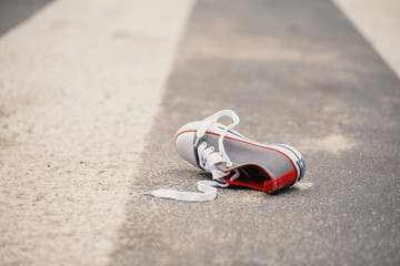 Child's shoe on the street after dangerous traffic incident
