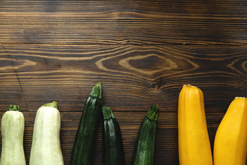 Autumnal harvest squash and zucchini variety on wooden background. Top view with copy space