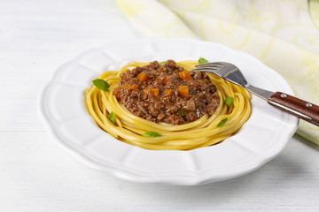 Pasta with bolognese sauce. In a white plate. The background is white. Italian food.