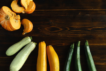 Autumnal harvest squash and zucchini variety on wooden background. Top view with copy space