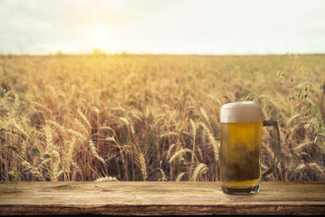 Beer keg with glasses of beer on rural countryside background