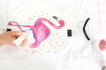 painting on fabric, flamingos on a vest. Drawing with paints.