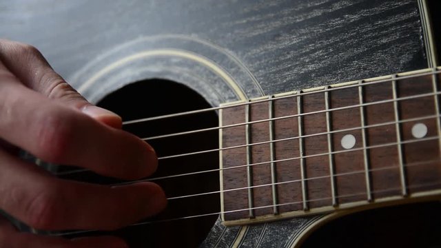 Plays the guitar closeup