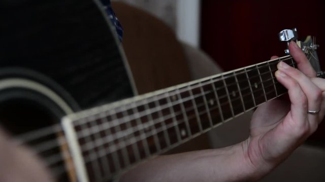 Plays the guitar closeup