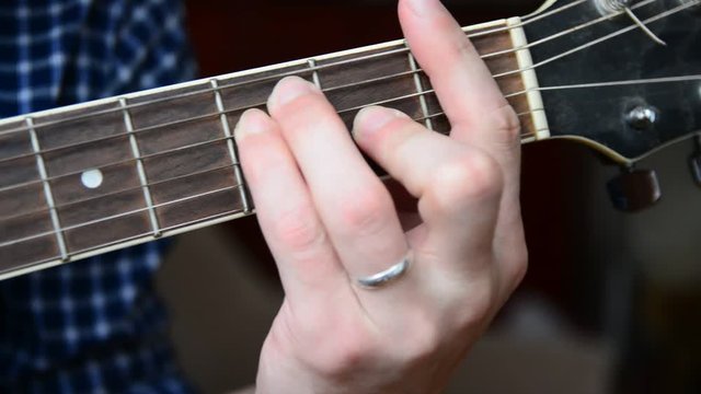 Changing the chords on the guitar close-up