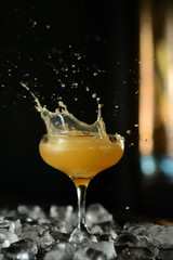orange cocktail in a glass with ice on a dark background