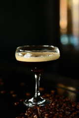orange cocktail in a glass with ice on a dark background