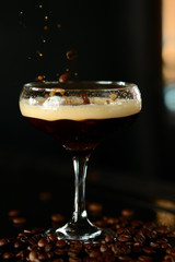 orange cocktail in a glass with ice on a dark background