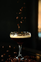 orange cocktail in a glass with ice on a dark background
