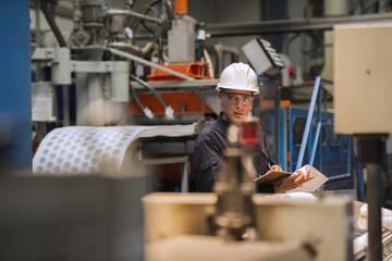 Factory worker with clipboard in factory