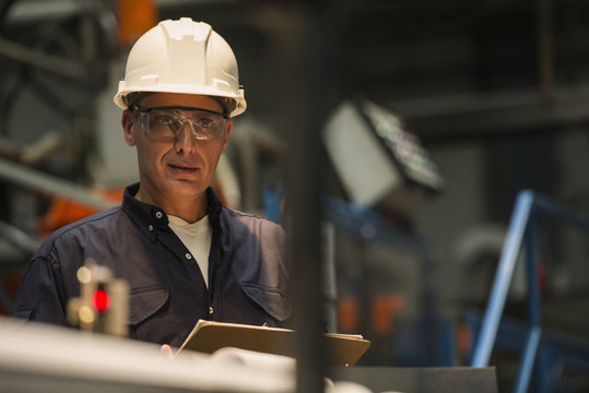 Factory worker with clipboard in factory
