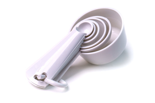 Measuring set table spoons and cups plastic white color isolated on white background. Devices, measuring ingredients for cooking preparation
