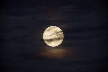 Bright full moon against dark clouds