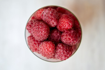 juicy fresh raspberries in a glass up view