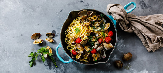 Pasta Spaghetti alle Vongole Seafood pasta with Clams in frying cooking pan on concrete background copy space