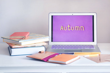 Workspace with laptop lying on wooden desk.  Autumn is coming. Back to school.