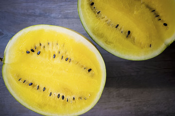 Yellow watermelon on a gray wooden table.