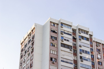 Horizontal detail shot of tall concrete mass housing building corner in Izmir at Turkey with blue...