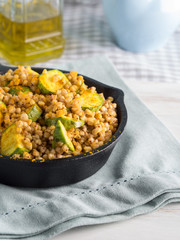 Buckwheat with zucchini and turmeric in cast iron skillet. Easy and healthy lunch for celiac gluten free diet