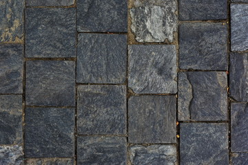 Dark pavement with cobblestone square blocks of natural stone