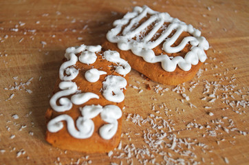 Christmas gingerbread decorated with white icing lie on a wooden table