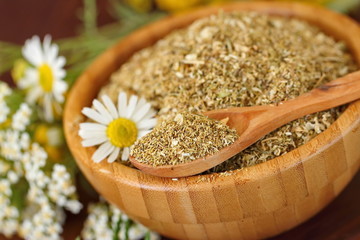 Dry herbal tea in wooden bowl
