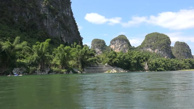 Wild nature of Li River from the motorized rafting boat, FPV. Yangshuo, Guilin, Guangxi Zhuang, China