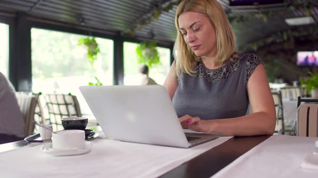 Woman is working on laptop in cafe