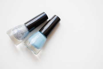 silver and blue nail polish on white background