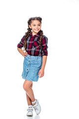 schoolchild in denim skirt and checkered shirt posing and looking away isolated on white